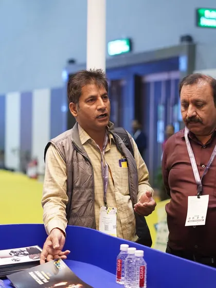 An exhibitor explains product features to an interested visitor, showcasing the valuable one-on-one interactions at the expo.