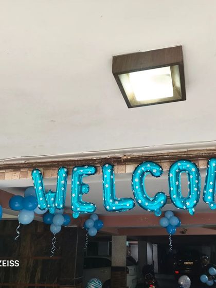A simple "WELCOME" foil balloon setup at the entrance of a home to celebrate the arrival of a new baby boy.