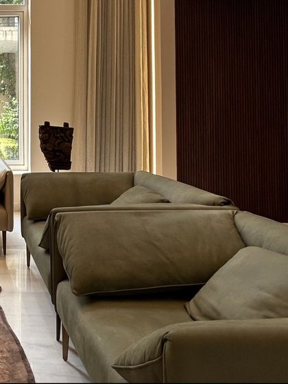 The combination of different sofa styles and materials adds depth and interest to the living room seating arrangement. This approach allows for both formal and informal seating options within the same space.