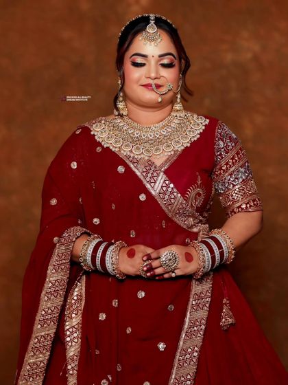 This bride looks serene and beautiful in a deep maroon lehenga. Her hair is styled in an elegant updo, adorned with flowers that add a soft, romantic touch.