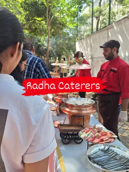 A view of the buffet line at an outdoor party, with our staff ready to assist guests. A fresh fruit salad is also part of the spread.
