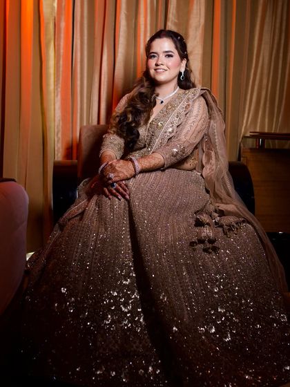 A full-length shot of Vidushi's engagement outfit. The heavily embellished lehenga is perfectly balanced with soft, elegant makeup.