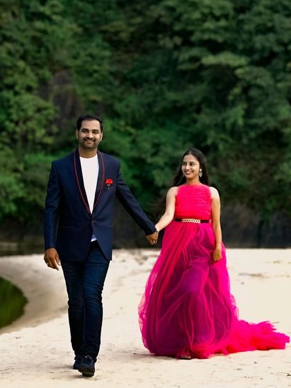 A happy couple walking on the beach. The flowing pink gown is perfect for a relaxed and romantic pre-wedding shoot by the water.