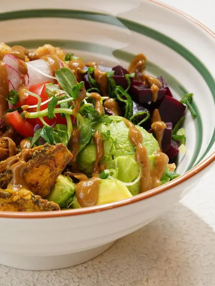 A close-up of a colorful and healthy salad bowl, showing the variety of fresh ingredients and textures.