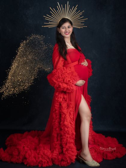 A powerful and glamorous portrait. This mom-to-be looks like a goddess in a red gown, complete with a golden halo and sparkling angel wing.