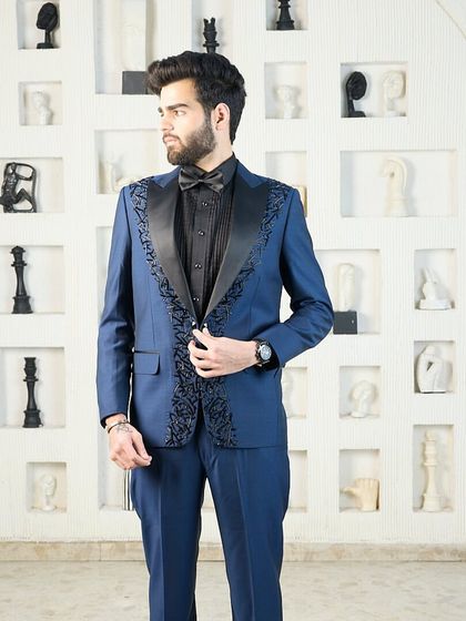 The intricate black-on-blue embroidery on this tuxedo lapel is the focus here, showcasing the fine craftsmanship that goes into each bespoke piece.