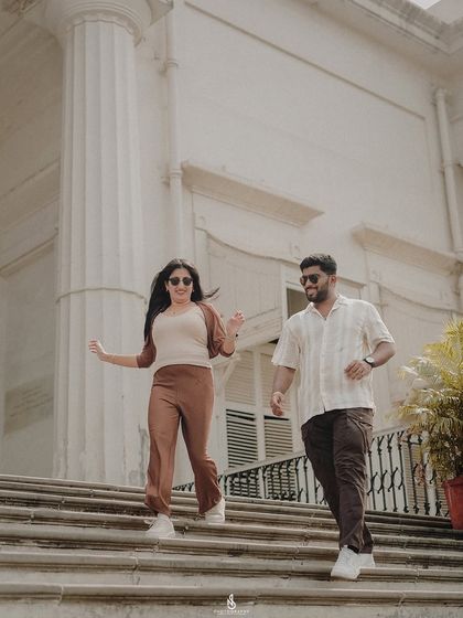 A dynamic shot of the couple walking down a grand staircase, full of movement and style.