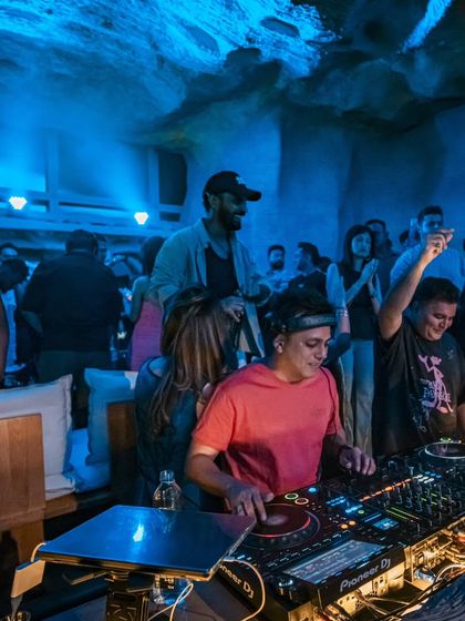 A cool, blue-lit shot from a gig at Bastian, with friends and fans gathered around the console.