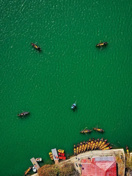 The final, color-graded top-down view of boats on the emerald green waters of Nainital lake. This is the full version of the shot seen in the transition video.