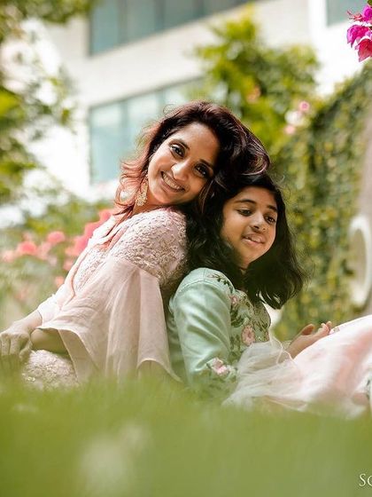 A quiet, tender moment between a mother and daughter sitting back-to-back on the grass. Amidst the play, we always make time for these gentle, connected portraits.