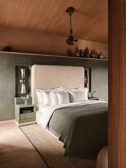 This bedroom at Embassy 821 is a sanctuary of calm, designed with a muted palette of olive green and beige. The custom headboard niche and artisanal side tables demonstrate our focus on integrated, intentional design.