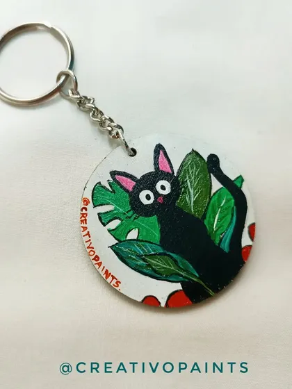 A close-up of a Jiji keychain, inspired by Studio Ghibli's "Kiki's Delivery Service." I love capturing the personality of beloved characters like this little black cat among the leaves.