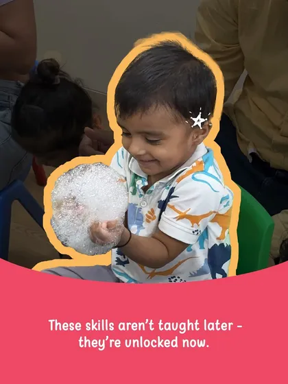 Look at the pure joy of discovery! This little one is holding a handful of bubbles, a simple sensory activity that unlocks so much learning. We believe that essential skills like creativity and problem-solving aren't just taught later in school; they are unlocked right now through play.
