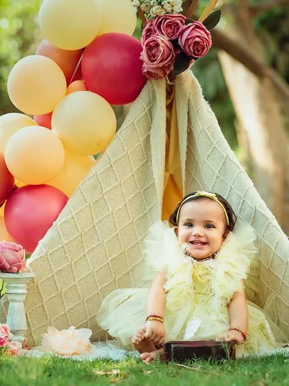 A sweet, smiling portrait from the same outdoor teepee session, showing a calmer moment of enjoyment.