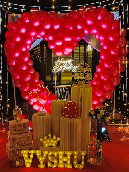 We specialize in creating unforgettable romantic surprises. This stunning outdoor cabana setup features a heart-shaped balloon arch, a red carpet entrance, and magical fairy lights, perfect for a birthday or anniversary celebration.
