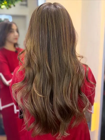 A final look at the beautiful milk tea brown transformation. The color looks stunning against her red top, showing its versatility.