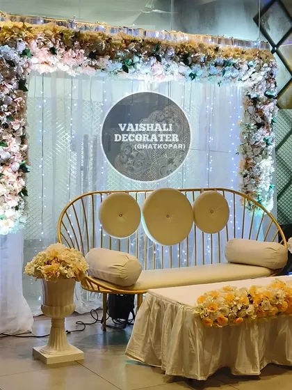 This elegant stage setup is perfect for engagements or intimate receptions. The rental includes a modern gold-finish sofa, a backdrop of sheer white curtains with fairy lights, and a beautiful floral border.