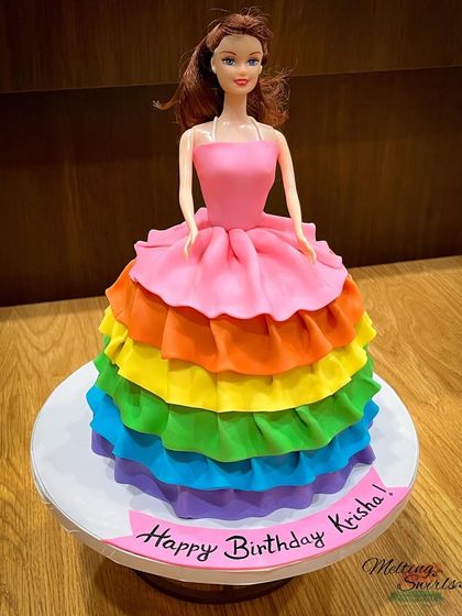 A custom Barbie doll cake with a stunning rainbow ruffle dress made entirely of fondant. This cake is a true showstopper and perfect for a Barbie-loving birthday girl.