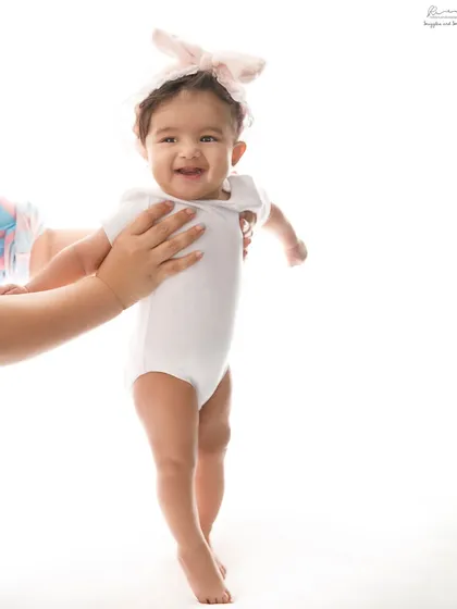 A big, confident smile from a baby who is just learning to stand with a little help. Capturing these achievements is so rewarding.