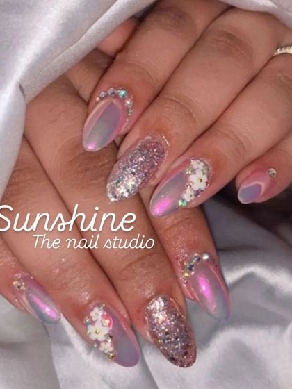 Shiny nails for happy trails. This design features a beautiful iridescent chrome, chunky glitter, and small 3D flowers, showing how to balance multiple textures and finishes.