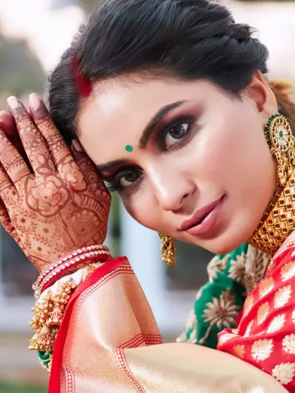 A detailed shot of the reception makeup, highlighting the intricate henna and the bold smokey eye. The combination of traditional elements with glamorous makeup creates a powerful style statement.