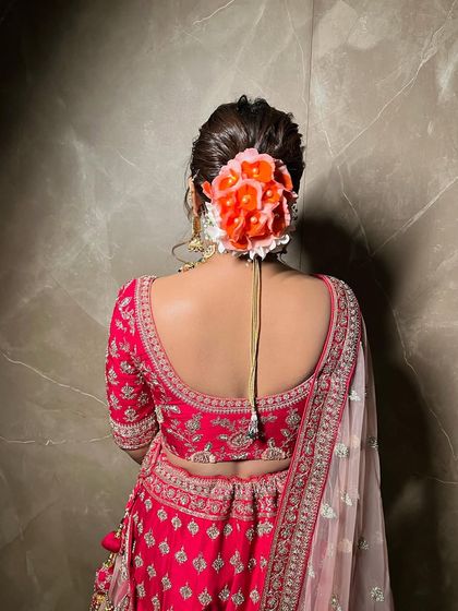 A full view of the textured bridal bun with fresh flowers. This style is perfect for brides who want a traditional yet vibrant look on their wedding day.