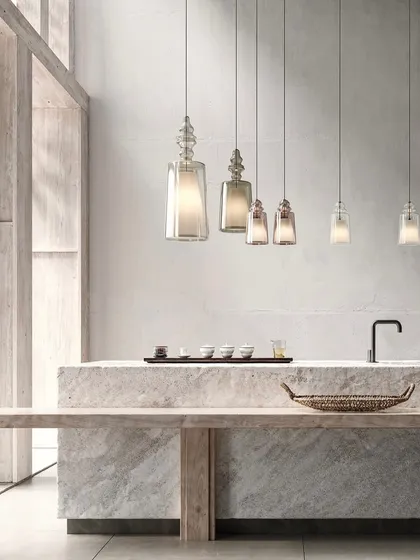A linear arrangement of the Matteo Ugolini pendants over a minimalist stone counter. This shows how they can be used to create a simple, elegant rhythm in a space.