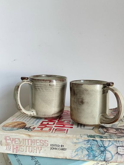 A collection of my handmade ceramic mugs, each with its own unique shape and glaze. The little coffee bean detail on the handle is a fun touch for coffee lovers.
