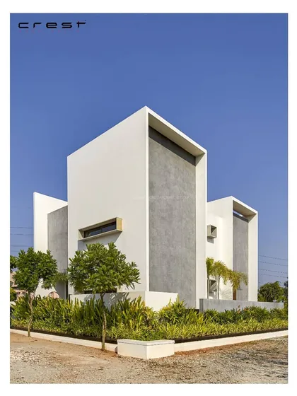 The 'Framed House' facade is composed of intersecting white and concrete-textured planes that create framed views and openings. The minimalist design carves a distinct niche in its landscape.
