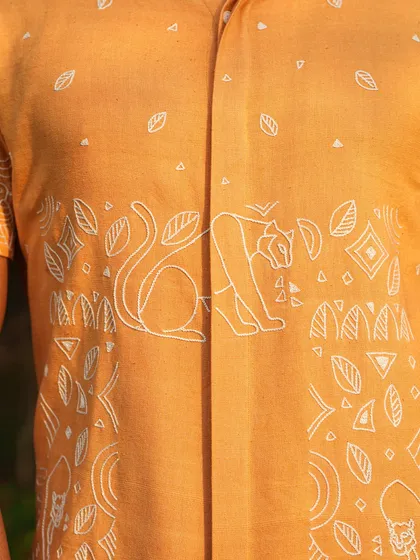 A close-up of the intricate hand-embroidered panther line drawings on our tangerine orange shirt. The design is a narrative of strength, crafted for the man with a 'let's get it done' approach.