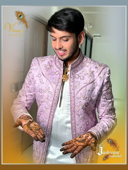 A candid shot of the groom enjoying his stunningly detailed mehndi.