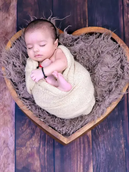 The pure innocence of a newborn is something we cherish. This simple, heartfelt pose in a heart-shaped basket is a timeless way to remember how small they once were.