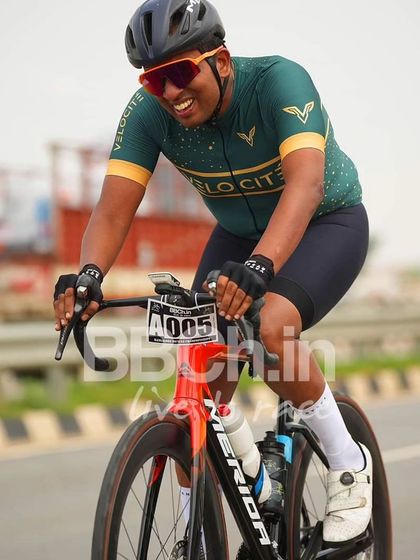 A rider from the Velocite racing team, smiling as he races.