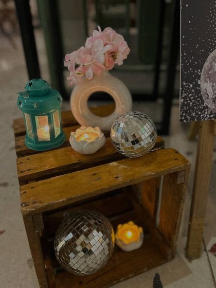 Small decorative corners add to the overall ambiance. Here, we used wooden crates, disco balls, and candles to create a rustic-glam vignette.