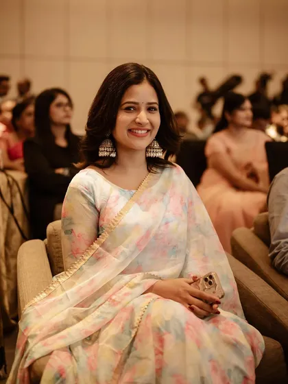 A candid portrait of actress Brinda Acharya, captured during an event. Her natural smile and the soft lighting create a warm and personable image.