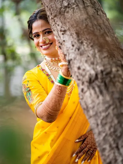 A playful peek from behind a tree. This candid shot shows the bride's joyful spirit, enhanced by her fresh and sunny makeup look.
