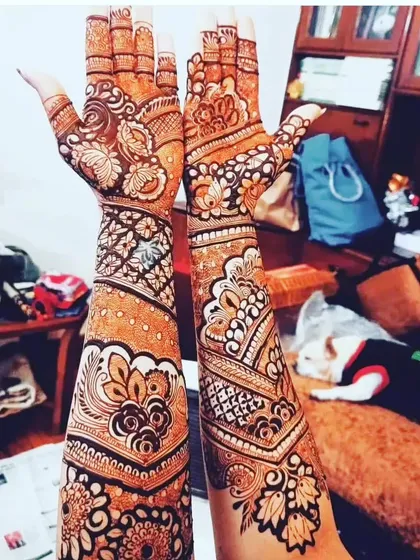 A classic Arabic-inspired fusion design. The pattern features bold floral and vine motifs that flow diagonally across the hands and arms.