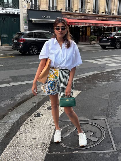 A classic Paris street style look. A simple white shirt paired with printed shorts and white sneakers is my formula for a chic and comfortable day of exploring.
