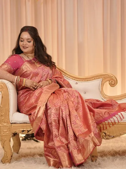 A relaxed portrait of our Bengali bride at her reception, looking elegant in a pink saree.