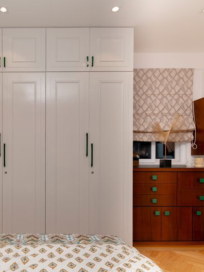 A closer look at the custom wardrobe and chest of drawers, where the repetition of the green handles creates a sense of harmony and rhythm.
