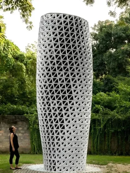 A person observes the full height of the VERTO tower, appreciating its scale and design.