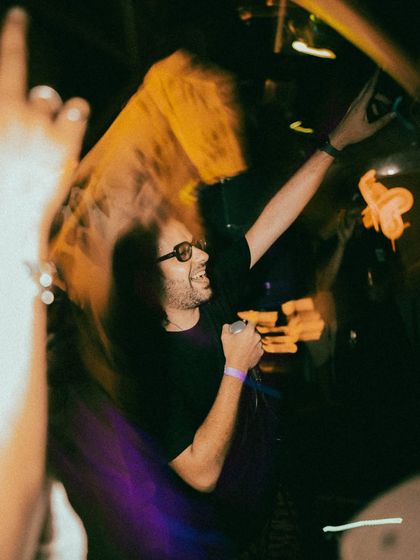 Caught in a moment of pure energy, hyping the crowd on the mic. This is what it's all about, feeding off the room's vibe and giving it right back.