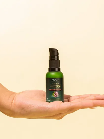 A lifestyle shot showing Biofresh Botanicals' face serum held in the palm of a hand. This personalizes the product and shows its scale.