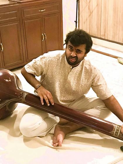 One of our musicians having a playful moment with a tanpura. We believe that joy and play are essential parts of the musical creation process.