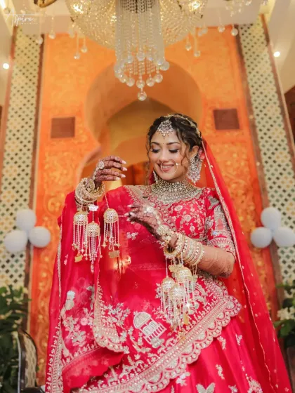A bride's quiet moment of reflection. We captured Devanshi admiring her kalire, a small, personal gesture filled with anticipation and tradition. It’s these unposed, candid portraits that tell the most beautiful stories.