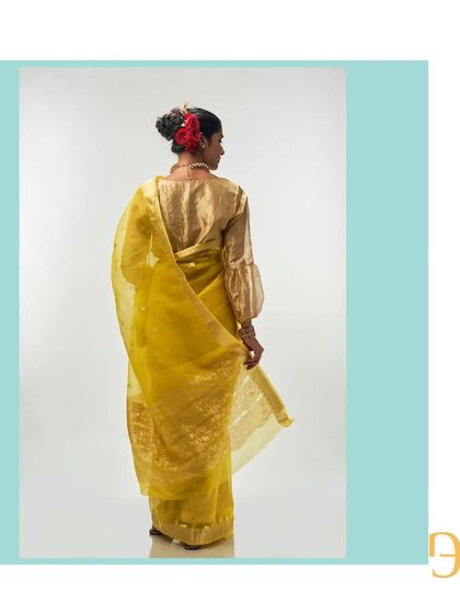 The back view of the cadmium yellow saree, paired with a golden blouse to complement the zari work.