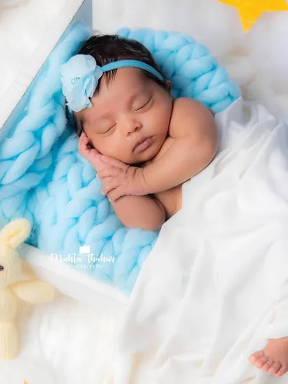 A wider view of the sleeping newborn, tucked into a tiny bed with a bunny friend, surrounded by glowing stars.