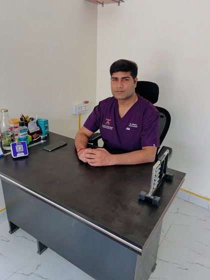 A photo of me at my desk in the clinic. This is where I conduct initial consultations to properly examine patients and create a personalized treatment plan before any therapy begins.