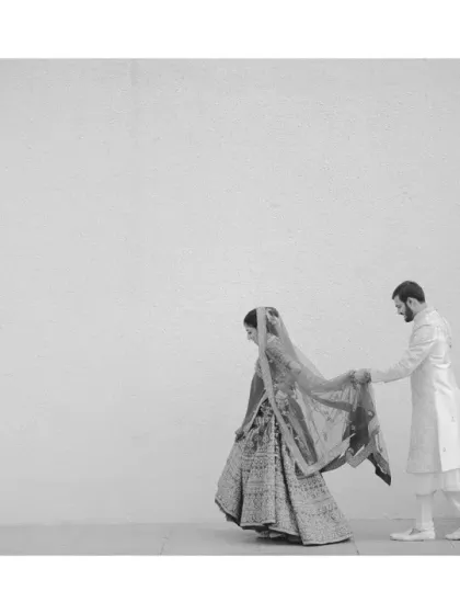 A quiet, unnoticed moment where the groom holds his bride's dupatta so she can walk freely. Stripped of colour, this small gesture of care becomes a powerful statement about their companionship.