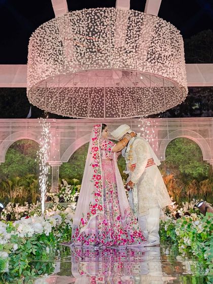 A romantic shot of the couple on their special day, framed by the lush, sustainable decor. The soft lighting and abundant florals create a fairy-tale ambiance.